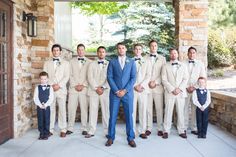 a group of men standing next to each other in front of a brick wall and door