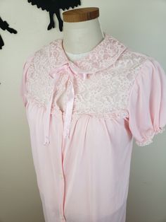 Description: Adorable 1950's/1960's light pink bed jacket. Features 5 buttons down the front and ties for a bow at the neckline with puff sleeves. Has a peter pan lace collar and detailing along the top of the bodice. Measurements Bust: 34/36 inches Waist: 36 inches Length: 36 inches Size suggestion (but please go by posted measurements): Small or Medium Condition: Good condition, seams along the lace at the neckline shown some wear. There is one large run on the back left hand side, shown in th Light Pink Bed, 60s Lounge, 1950s Shirts, Pink Bed, Bed Jacket, Womens Lingerie, Shirtwaist Dress, 60s Dress, Pink Bedding