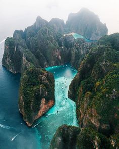 an aerial view of the ocean with rocks and blue water in between two large islands