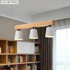 three lamps hanging from the ceiling above a book shelf