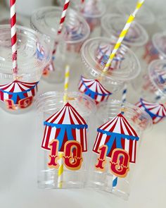 there are many cups with straws in the shape of circus tents and numbers on them