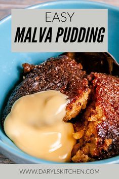 a blue bowl filled with pudding and cream next to a spoon on top of a wooden table