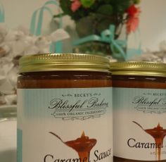 two jars of caramel sauce sitting on a table