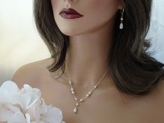 Elevate your wedding day look with this cream pearl Y backdrop bridal necklace and earring set. The front Y design features Swarovski crystal and pearl accents with a 1 inch pearl pendant drop. The elegant back detail is the perfect finishing touch. Necklace available in 16, 17 or 18 inches + a small extender chain. Backdrop length available in 6 or 8 inches. Earrings measure 1.5 inches in length including the ear wire. Items arrive in a beautiful hand decorated gift box. Ready to ship in 3-5 business days. Pearl Drop Backdrop Necklace For Wedding, Pearl White Wedding Backdrop Necklace With Pearl Drop, Elegant Gold Backdrop Necklace For Bride, Pearl Backdrop, Gold Bridal Jewelry, Backdrop Necklace, Backdrops Necklace, Pearl Bride, Gold Bridal Jewellery Sets