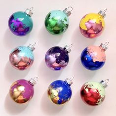 six different colored christmas ornaments on a white surface