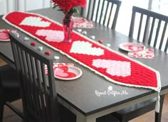 the table is set for valentine's day with red and white crocheted hearts