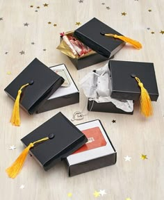 five graduation caps with yellow tassels are sitting on a table next to some books