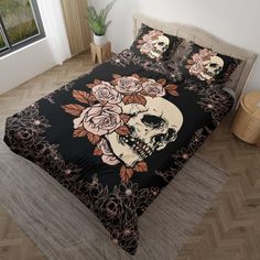 a bed covered in black and pink flowers with a skull on the back ground next to a window