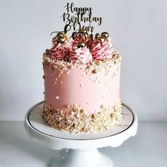 a birthday cake with pink frosting and gold sprinkles