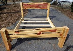 a wooden bed frame sitting on top of a sidewalk