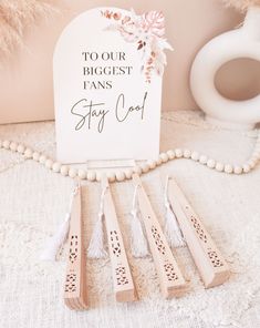 wooden pegs with tassels are sitting next to a sign that says, tour the biggest pans stay cool