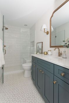 a bathroom with white tile and blue cabinets