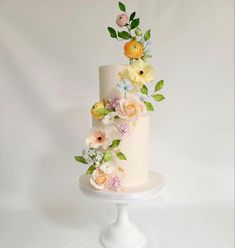 a three tiered white cake with flowers on top