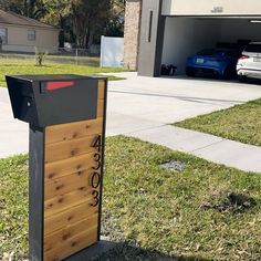 a mailbox sitting in the grass next to a driveway