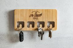 a wooden key holder with four keys hanging from it