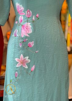 a woman's dress with pink flowers painted on it