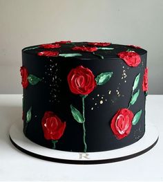 a black cake with red roses on it