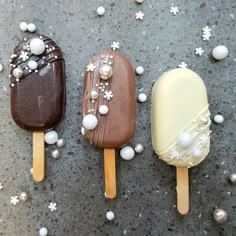 three ice creams are sitting on top of each other in different colors and shapes