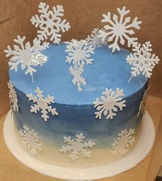 a blue cake with white snowflakes on it