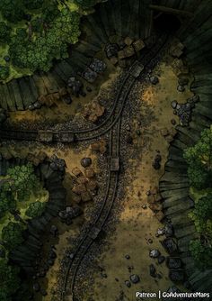 an aerial view of a train track in the middle of some trees and dirt area