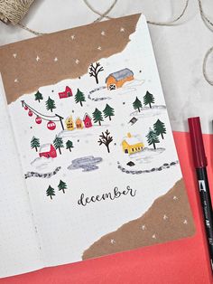 an open notebook with the words december written on it next to some crayon markers