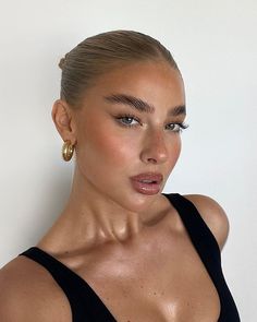 a woman in black top with gold hoop earrings on her head looking at the camera