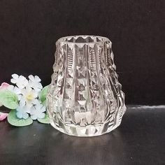 a glass vase sitting on top of a table next to flowers