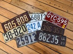 five different license plates laying on top of a wooden floor