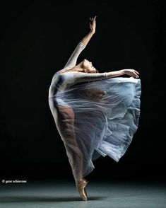 a ballerina is dancing in the dark