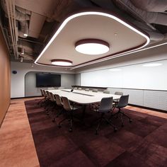 an empty conference room with white tables and chairs