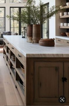 a large kitchen with wooden cabinets and white counter tops, along with open windows to the outside