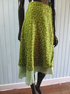 Vintage silk wrap skirt in lovely spring green with yellow flowers. Has a contrasting underskirt.  Dimensions: Waist flat: 46 Inches. Length: 32 Inches. Made in India Green Knee-length Dress With Flowy Skirt, Hippie Style Lined Wrap Skirt For Spring, Hippie Lined Wrap Skirt For Spring, Hippie Wrap Skirt With Lined Skirt For Spring, Green Dresses With Flowy Skirt, Green Silk Dresses With Flowy Skirt, Green Floral Print Skirt For The Beach, Green Skirted Dress For Summer, Green Summer Dress With Lined Skirt