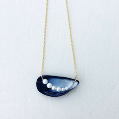 a blue necklace with pearls hanging from it