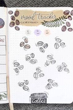 an open notebook with coffee beans on it and the words mood tracker written in cursive writing