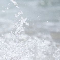 the water is splashing on the beach and it appears to be very close up