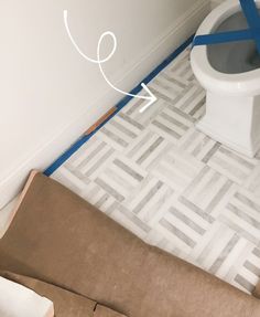 a toilet sitting on top of a cardboard box next to a brown bag with blue tape around it