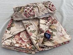 a pair of shorts with floral print on them sitting on top of a white sheet