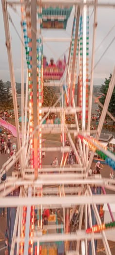 an aerial view of a carnival ride with people riding on the rides and in the background