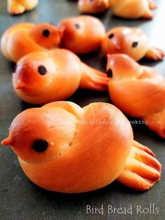 some little orange birds sitting on top of a black table with holes in the middle