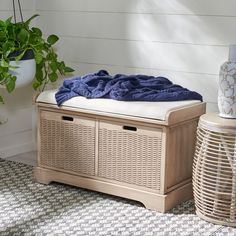 a wooden bench sitting on top of a rug next to a potted plant and basket