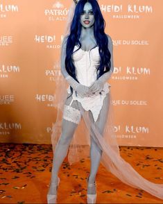 a woman with blue hair and makeup is dressed up