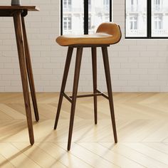 two stools in the middle of a room with windows and a table next to them