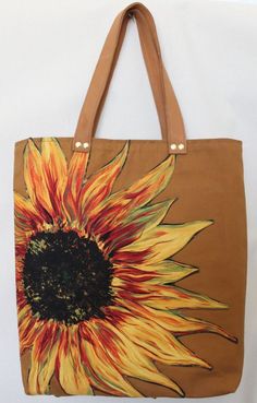 a brown bag with a large sunflower painted on the front and side of it