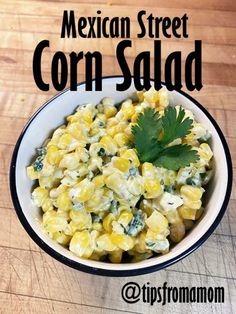 mexican street corn salad with cilantro and parsley in a white bowl on a wooden table