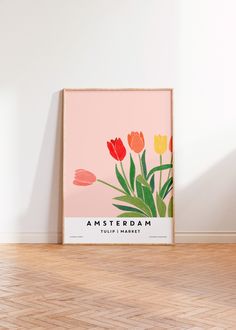 a pink and yellow poster with tulips on the wall in front of it