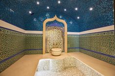 an elaborately decorated bathroom with blue and green tiles on the ceiling, walls and floor