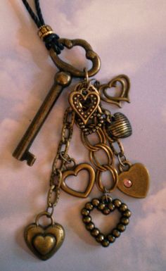 a bunch of keys that are attached to a chain on a white surface with clouds in the background