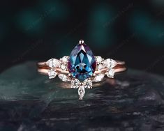 a blue and white diamond ring on top of a rock