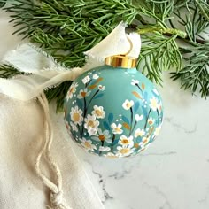 An extra special, hand-painted Christmas ornament perfect to gift or hang on your own tree! I carefully paint each ceramic ornament from scratch using textured acrylic to give each one a unique and beautiful dimensional effect. Each ornament is sealed with a satin varnish to keep it protected.  This listing includes one ornament featuring tiny white daisies atop a vintage green background.  *This ornament is READY TO SHIP and is the ONLY one of its kind. This year I painted each and every orname Christmas Ornament Paintings, Diy Ornaments Paint, Cricut Christmas Ornaments Diy, Daisy Ornament, Hand Painted Christmas Balls, Painted Ornaments Christmas, Ornament Painting Ideas, Hand Painted Wood Ornaments, Christmas Ornament Painting