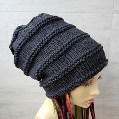 a mannequin head wearing a knitted hat with dreadlocks on it